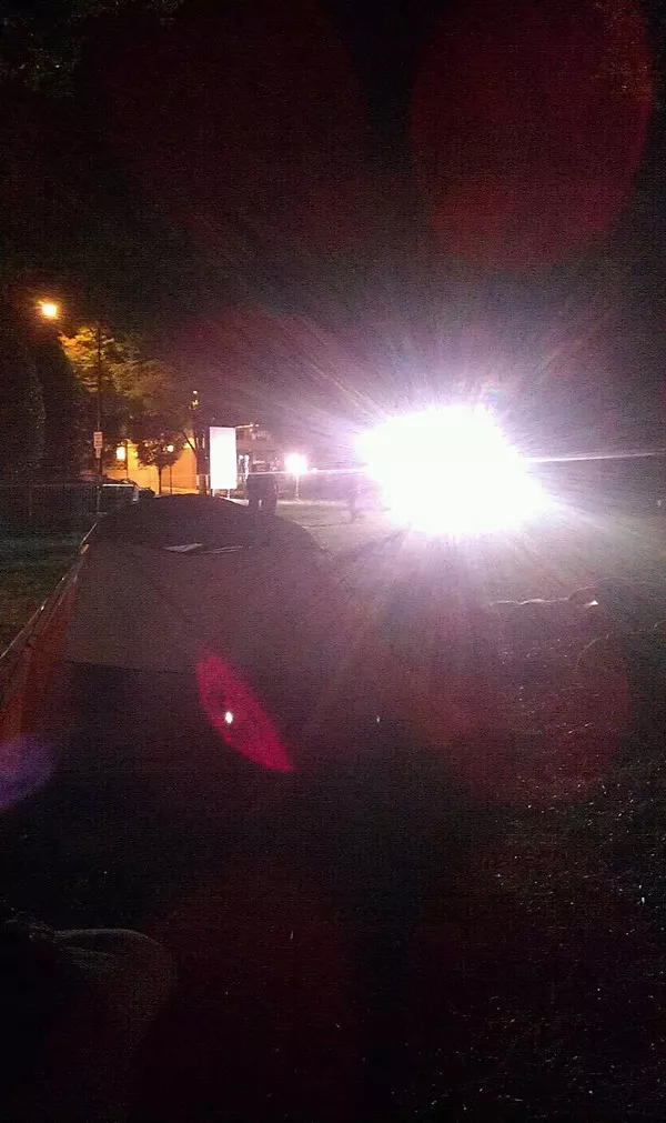 Television lights shining through a tent before 6 a.m. Sunday morning