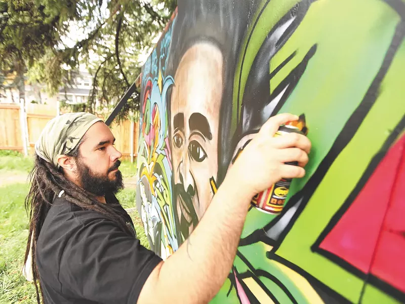Justo Luis Rodriguez, founder of Upful Creations, works on a mural in his back yard. - YOUNG KWAK