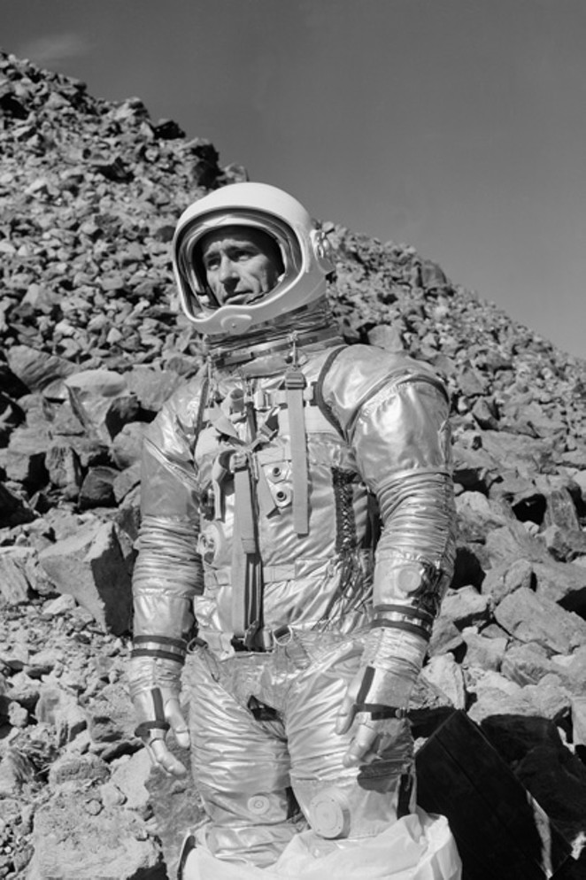 In 1964, Astronaut Walter Cunningham, in his pressurized suit, climbs a slope at the obsidian flow fields near Paulina Lake. - COURTESY NASA