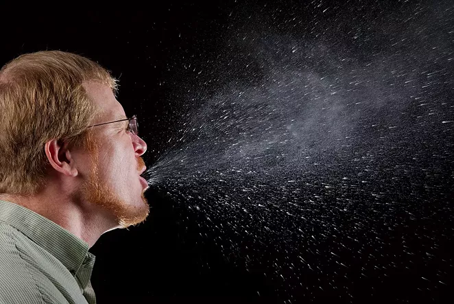 Capturing a sneeze in progress, demonstrating "the plume of salivary droplets as they are expelled in a large cone-shaped array from this man’s open mouth," according to the CDC. - JAMES GATHANY - CDC PUBLIC HEALTH IMAGE LIBRARY