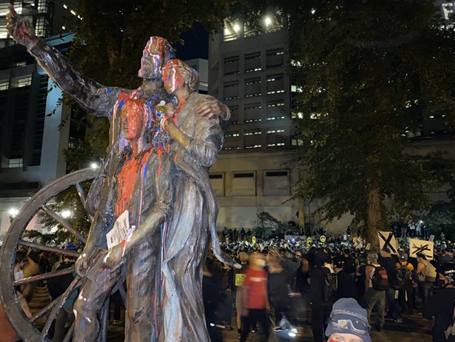 The "Promised Land" statue in Chapman Square, west of the Justice Center, defaced with paint. The statue was commissioned by the the Oregon Trail Coordinating Council to commemorate the 150th anniversary of the Oregon Trail, according to the City of Portland's website. - NICOLE VULCAN