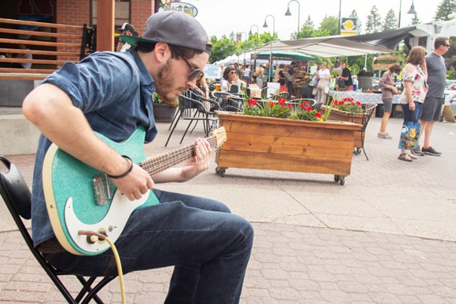 Street Performer Taylor Levin, pictured at left, - seranades shoppers at the Wednesday farmers market in downtown Bend. - KYLE SWITZER