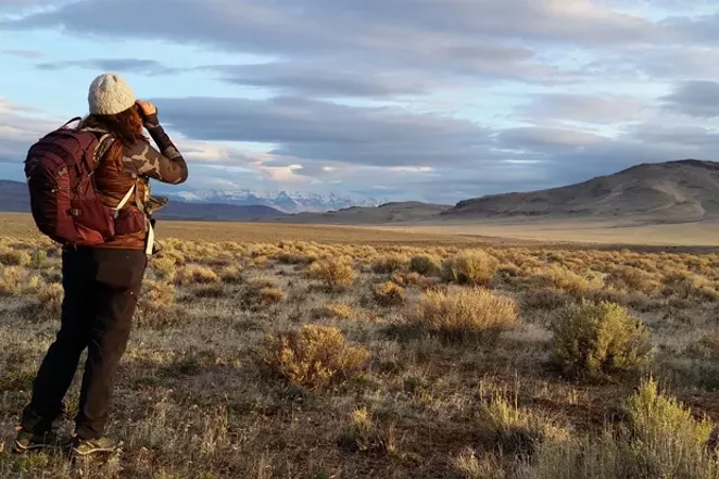 A day hiker scans for wildlife in the Oregon Outback. - DAMIAN FAGAN