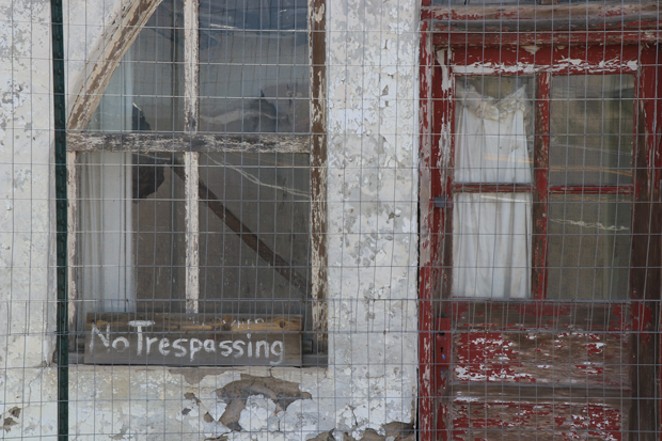 A 'No Trespassing' sign is left outside a decaying building in Brothers. - JACK HARVEL