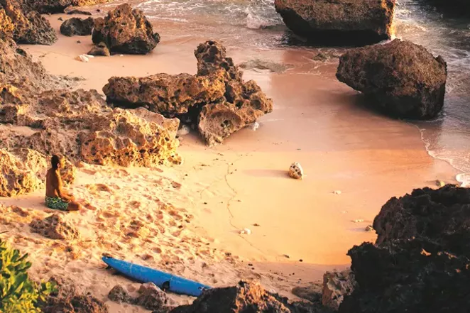Can you spot Lopez? Sitting on the beach Lopez, an avid yogi, meditates while facing the waves. - TOMMY SHULTZ