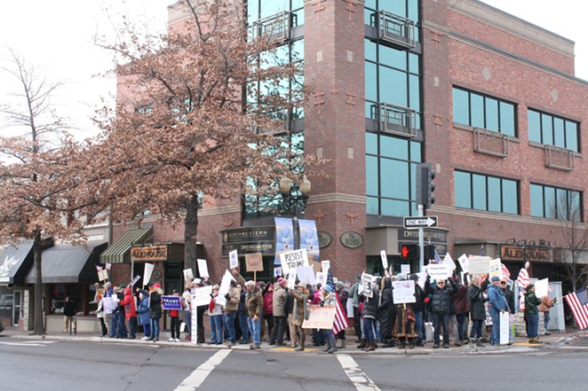 Demonstrators in front of Rep. Greg Walden's Bend office Tuesday. Ongoing demonstrations are scheduled for Tuesdays at 11:30 am. - NICOLE VULCAN