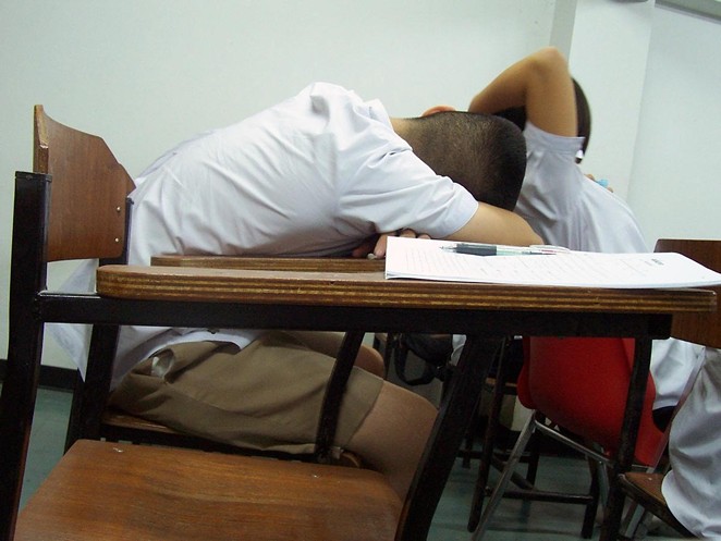 A student sleeps at his desk in Thailand. - LOVE KRITTAYA