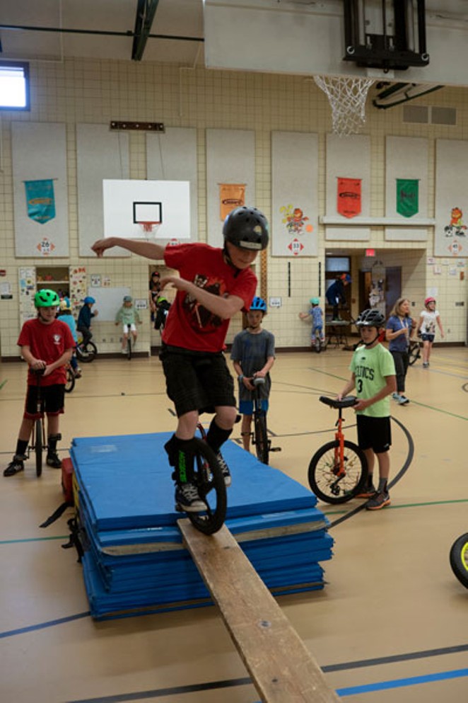 Jon DeGraff rides across a plank during the Pine Ridge Elementary's Unicycle Club practice. - CHRIS MILLER