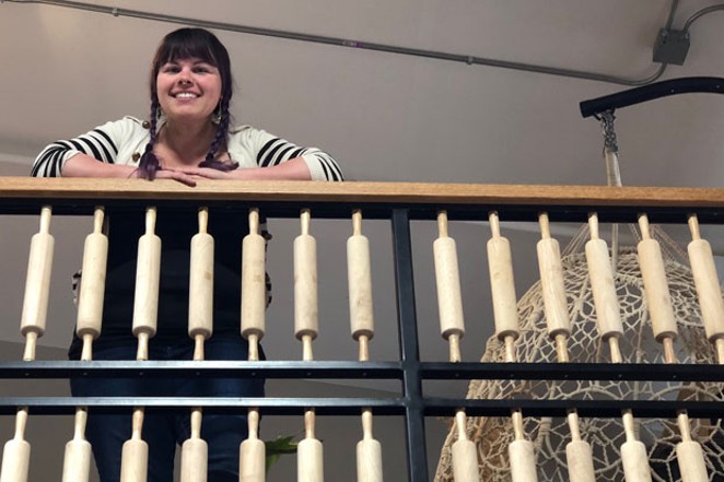 Pastry Chef and Owner Nickol Hayden-Cady looks out at the cafe as she rests her arms on the rolling pin-adorned railing. - LISA SIPE