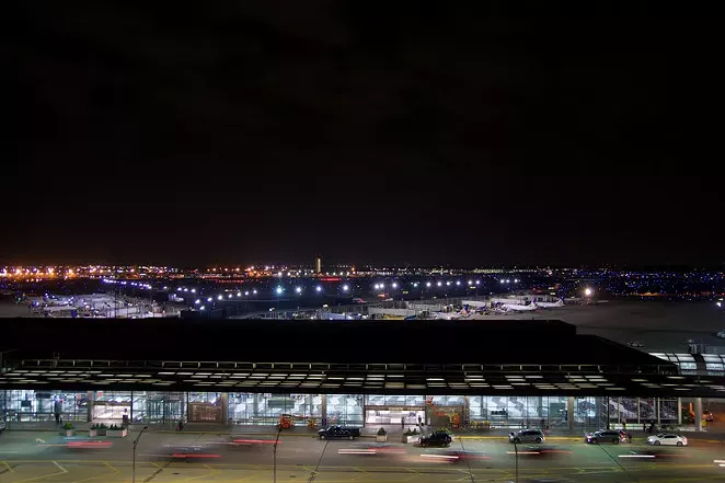 Outside of Chicago O'Hare International Airport at night with some cars and airplanes at the terminal. - CANSTOCKPHOTO.COM