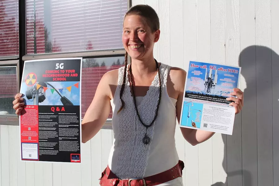 Katrina Rose, 39, passes out posters and fliers last Wednesday to get the word out about the health impacts of 5G cell towers. - LAUREL BRAUNS
