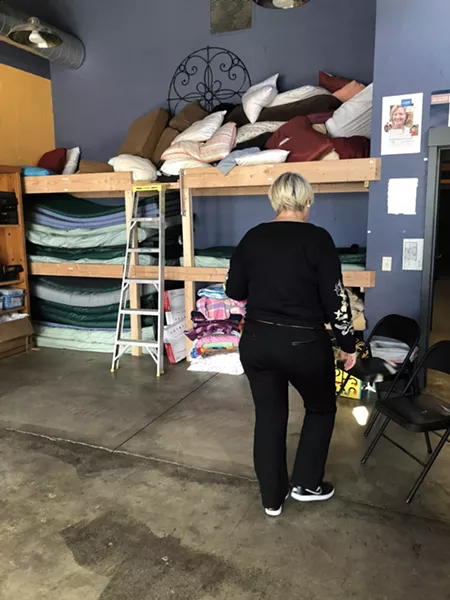 Sally Pfiefer moves chairs around to show off the new bunkbeds in the Sagewood Sanctuary. The room, inside Pfiefer & Associates, is home to group meetings and other support activities during regular business hours. - NICOLE VULCAN