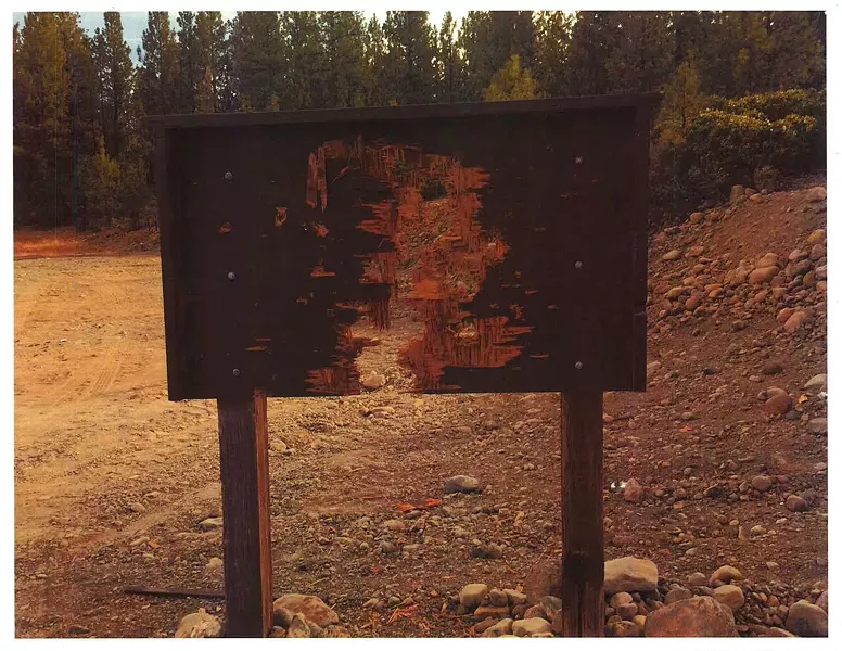 The same sign after being shot to pieces - SISTERS RANGER DISTRICT