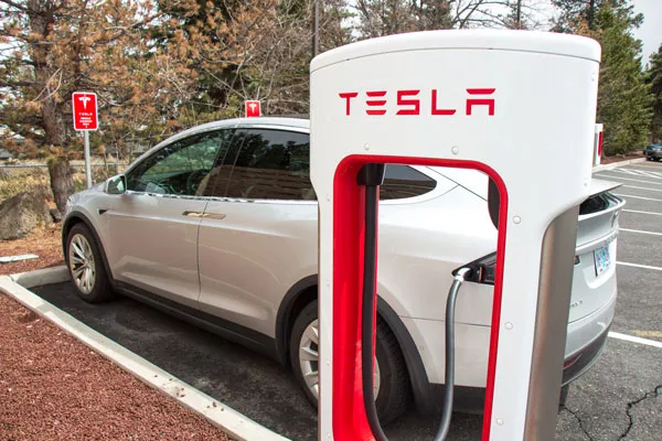 A Tesla charges at a charging station in the Fred Meyer parking lot in Bend. - KEELY DAMARA