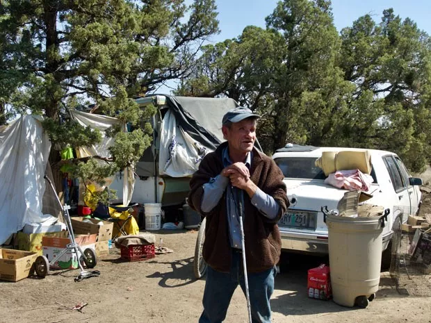 Mark, who is blind and homeless, leans on his cane in front of his camp on COID property east of Redmond in 2018. - SOURCE FILE PHOTO