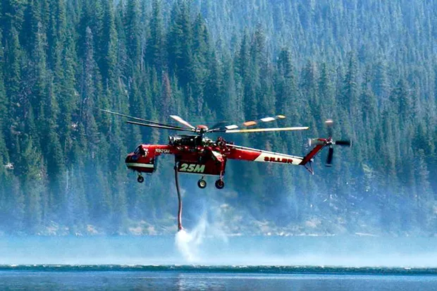 A helicopter picks up water to douse a fire on McKay Ridge in the Deschutes National Forest on Monday 7/29. - CHARLES BLUMENTHAL