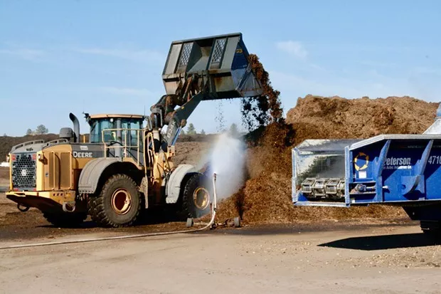 An employee stirs the pile of compost at the Knott Landfill in Bend. - CHRIS MILLER