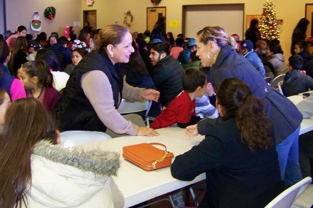 An overflow crowd of Latino families showed up for a free Christmas dinner at the Senior Center in Redmond in December 2018, hosted by the Latino Community Association. - DENISE HOLLEY
