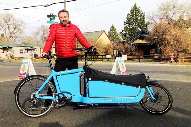 Stewart Fritchman, owner of Bellatazza Coffee, stands with the cargo bike he recently bought at Bend Electric Bikes to deliver coffee orders to his customers. - COURTNEY VAN FOSSAN