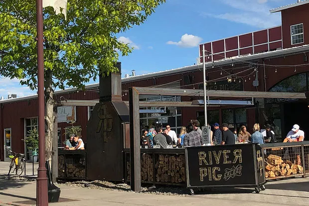 Bar-goers take advantage of nice weather on the River Pig Saloon patio. - CAYLA CLARK