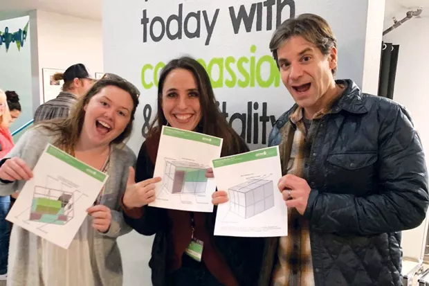 Makena Whitaker on the left (co-founder and project manager of Grownology), Ranae Staley in the middle (executive eirector of the Giving Plate), and Chris Fasan on the right (co-Founder and brand manager) with plans to build the first Grownology vertical garden at the giving tree. - COURTESY GROWNOLOGY
