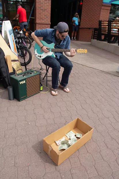 Street Performer Taylor Levin, pictured at left, - seranades shoppers at the Wednesday farmers market in downtown Bend. - KYLE SWITZER