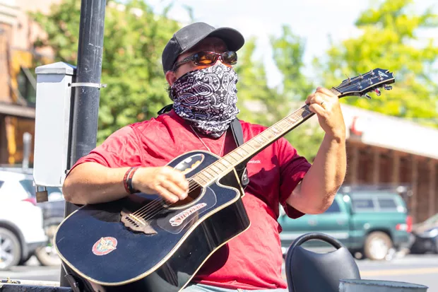 James Michel Miller, shown at right, strums his guitar at a downtown sweet spot, on the corner of Wall and Oregon, right outside of Goody's. - KYLE SWITZER
