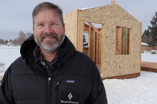 Bend Heroes Foundation President Erik Tibiason stands in front of one of the tiny homes under construction. - DARRIS HURST