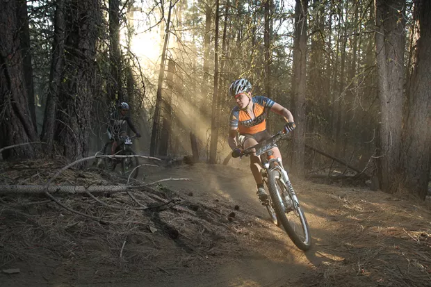 A rider soaks up the filtered rays on course running through the dense forests. - COURTESY MUDSLINGER EVENTS