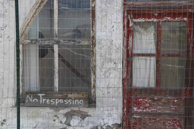 A 'No Trespassing' sign is left outside a decaying building in Brothers. - JACK HARVEL