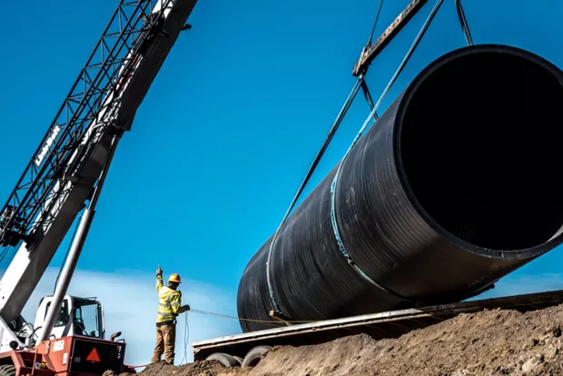 A construction worker signals to a crane operator while installing water piping for Central Oregon Irrigation District. - COURTESY CENTRAL OREGON IRRIGATION DISTRICT