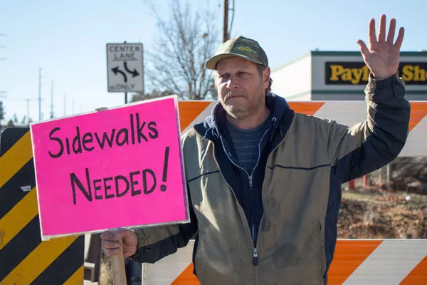 Rob, a volunteer with Advocates for Disabled Americans, Inc., pickets to raise awareness about ADA compliance on 1/13. - KEELY DAMARA