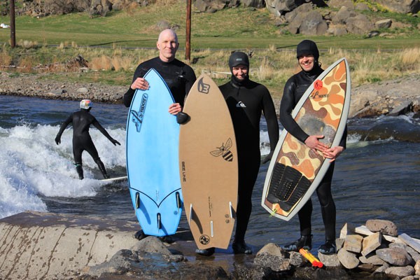 From left, Conway Bixby, Chris Caldentey and Kea Eubank hug their handcrafted river surfboards. - K.M. COLLINS