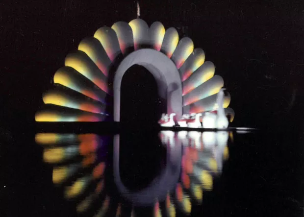The 1955 Bend Water Pageant Royal Court floats under the arch. - DESCHUTES COUNTY HISTORICAL SOCIETY