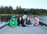 Camp kids smiling happily on a dock - Uploaded by Camp Fire