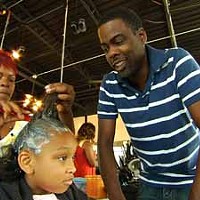 A HAIR-RAISING EXPERIENCE: Chris Rock watches a stylist at work in Good Hair.