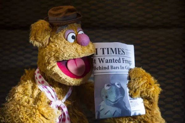 BLACK AND WHITE AND GREEN ALL OVER: Fozzie catches up on the day's news in Muppets Most Wanted. (Photo: Disney)