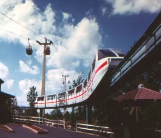 Carowinds old monorail system as it rounds a curve, passing under the also-gone Skyway Cable Lift and above the Oaken Bucket ride.