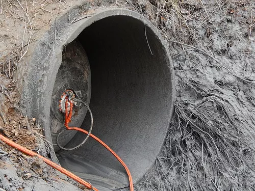 Dukes caption for the photo: The ruptured stormwater pipe was fitted with a temporary plug that, for a time, stopped the flow of water to the river while a permanent engineering solution was in development.