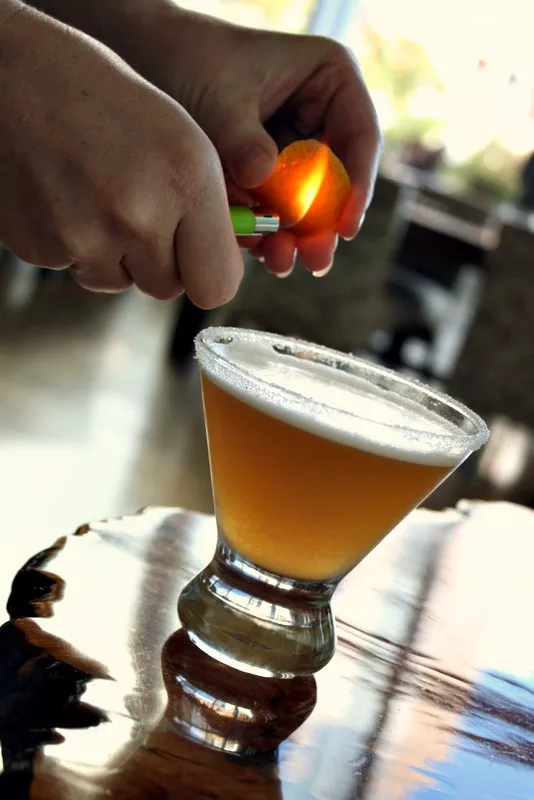 Light orange peel on fire and allow the orange oil to drip into the cocktail.