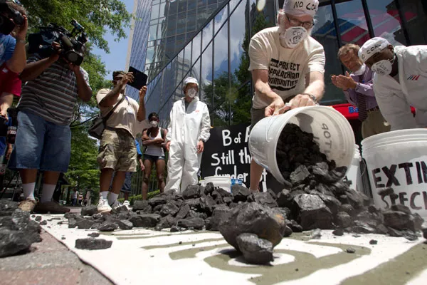 Photo captions: Activists dumped 500 pounds of coal in front of Bank Of America's headquarters during a street theatre protest Thursday to bring awareness to the bank's funding of the coal industry. - GRANT BALDWIN