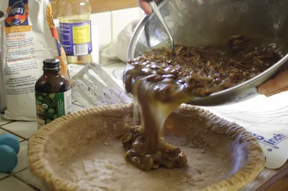 Pouring pecan pie filling into pan