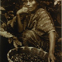 THE BIRTH OF COFFEE: A woman of Mayan descent from San Juan Atitl&aacute;n, Guatemala, sits with her basket of coffee beans.