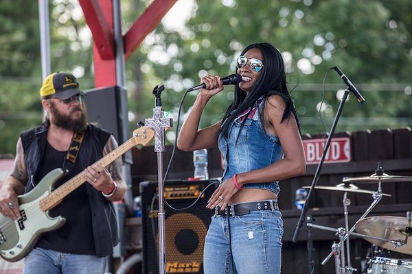 Adrienne Nixon Basco (foreground) and her bassist husband Rich Basco rock an outdoor stage with their band Tombstone Betty. (Photo by Cody Bennett)