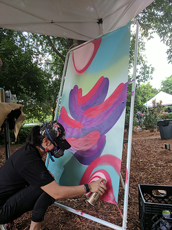Owl works on a piece at a recent Brand the Moth benefit at McGill Rose Garden. (Photo by Ryan Pitkin)