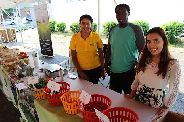 Brenda Montanez (right) with her fellow Sustainability Village volunteers at a recent Rosa Parks Farmer Market. (Photo by Ryan Pitkin)