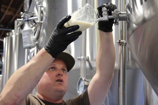 Brian Quinn pours the yet-to-be-named IPA from the tank. (Photo by Courtney Mihocik)