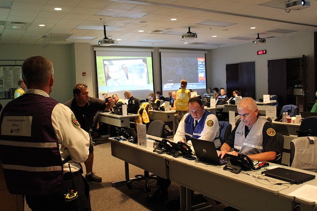Robert Cannon (left) in the EOC as personnel work on storm preparations. (Photo by Courtney Mihocik)