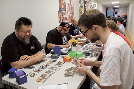 (From left) John Hartness, Jake Strunin and Owen Tavener play Magic: The Gathering at Rebel Base during a Monday night event. - KAILA BURTCH