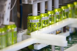 Cans of Hop DropN Roll come fresh off the canning line at Noda Brewing Company. (Photo by Jeff Hahne)